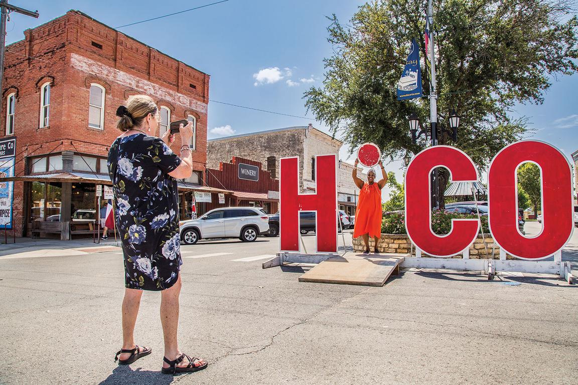 A woman has her picture taken posing as the "I" in Hico